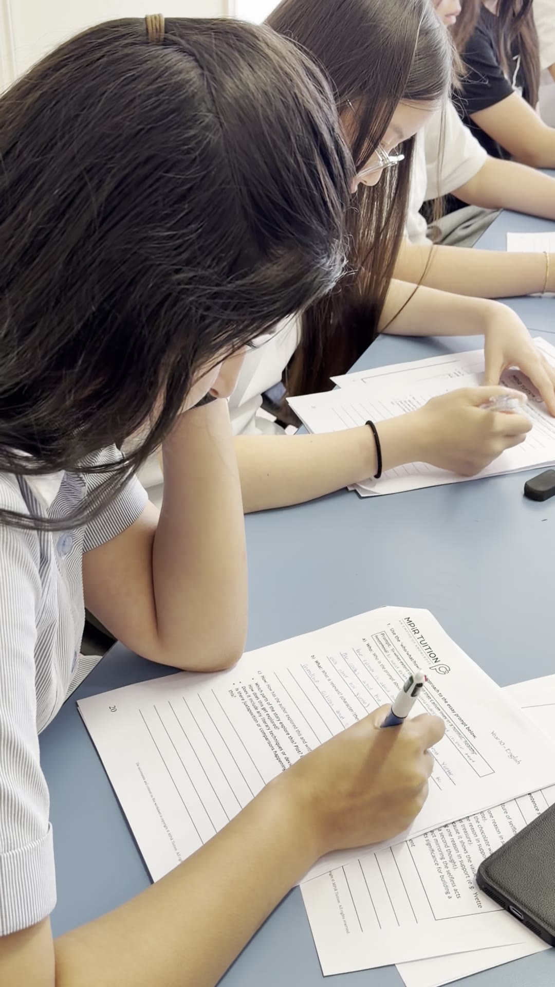 Students working through structured worksheets side by side